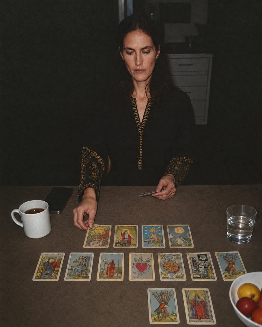 Amara as a younger woman, laying out tarot cards at her kitchen table