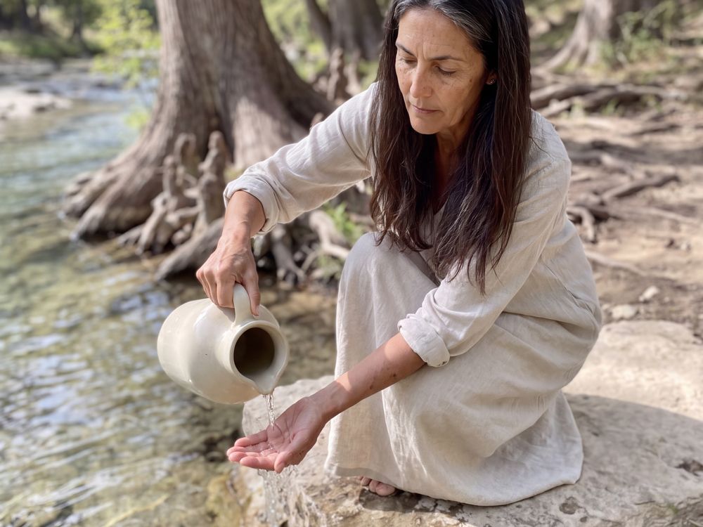 Amara pouring creek water over her hand